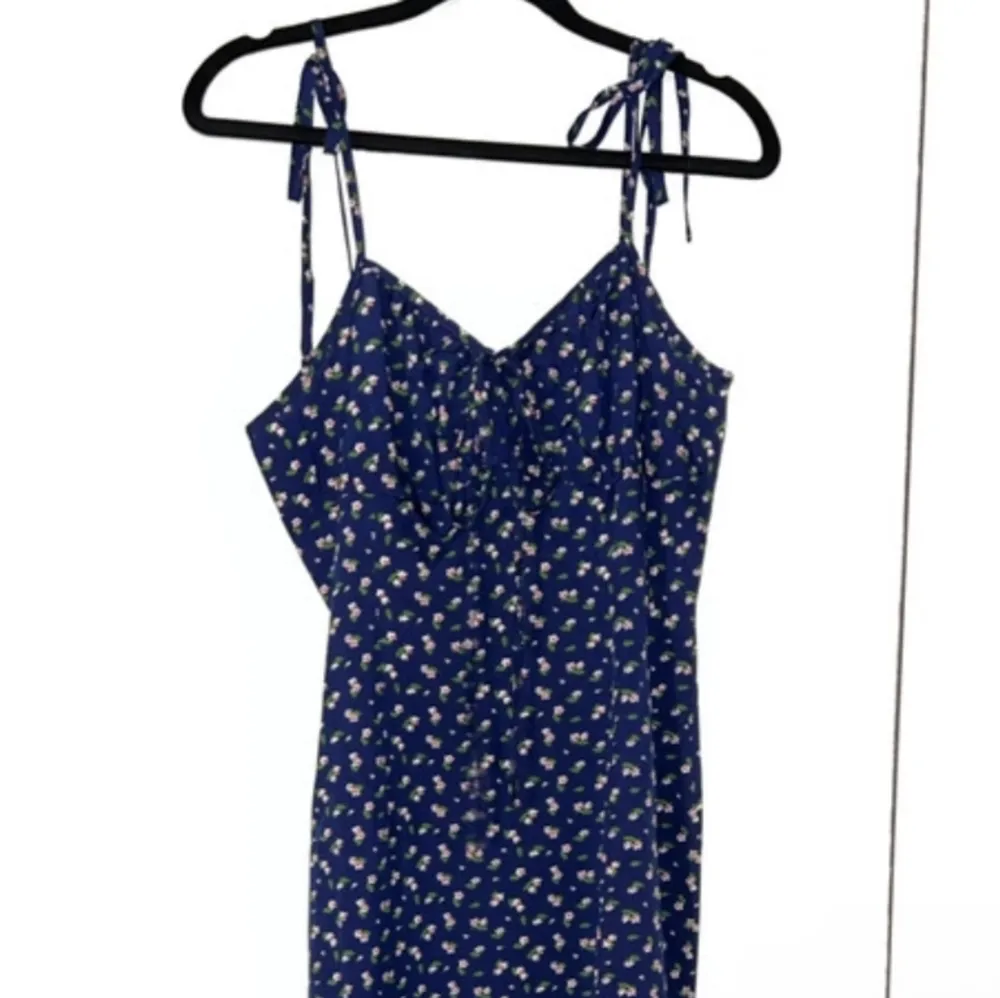 En tunn blå klänning med blommor på. Klänningen har en slits vid benet och axelbanden är knytbara♥️ Storlek: S♥️ ♥️♥️♥️. Klänningar.