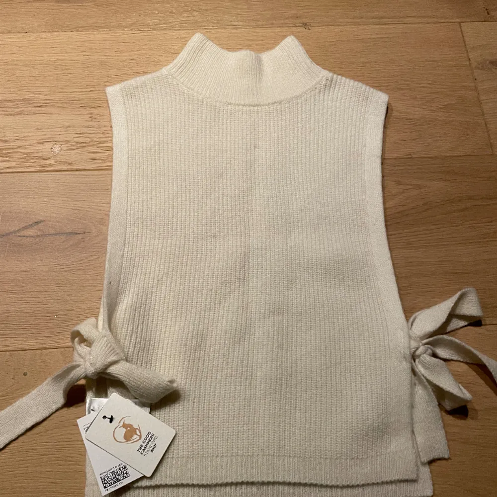 Cashmere pullover med liten polokrage, öppen i sidorna med rosett, helt ny, aldrig använd . Stickat.