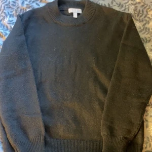 Svart stickad tröja  - Svart stickad tröja med slits i båda armarna, oanvänd 