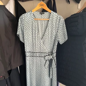 Klänning i siden - Säljer min jättefina turkosa siden klänning med svarta detaljer, pga att jag inte använt den på huur många år som helst, jättesynd! Bra skick, handtvättad två gånger, inga skador. Jag är 175cm lång för preferens🩵🩵