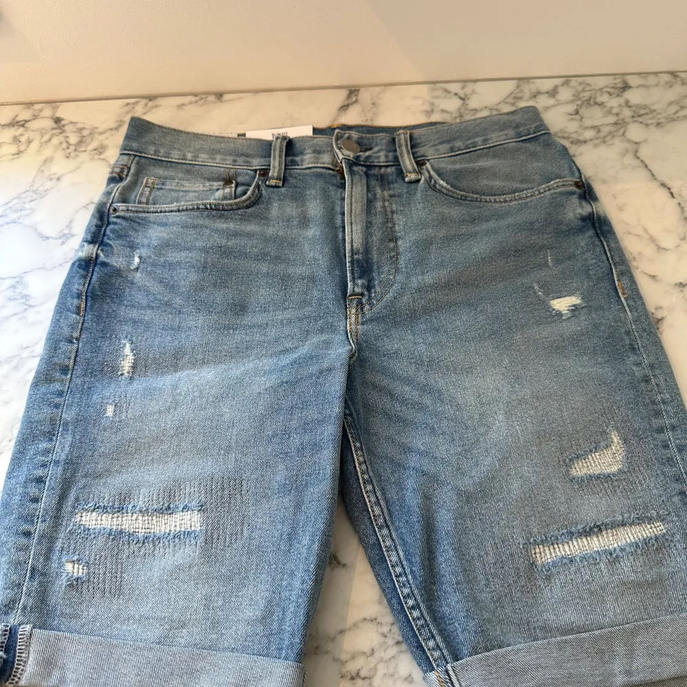 Ett par helt nya riva mörkblå jeansshorts. Shortsen är tunga men mjuka och sitter perfekt på kroppen. De har passformen slim fit och är tillräckligt luftiga för att spendera en hel sommar i de. Fick de i present av en släkting. . Shorts.