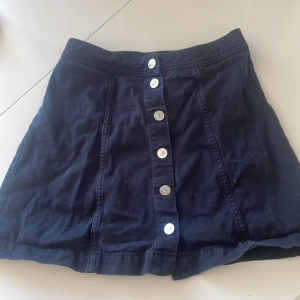 Svart minikjol - Svart minikjol med knappar. Väldigt fin men för liten för mig tyvärr. 