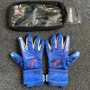 Reusch Målvaktshandskar Gold grip - Ett par riktigt snygga och bra målvaktshandskar. Den högsta andelen av materialet på handskarna är latex, vilket hjälper med greppegenskaperna!  Handskfodralet ingår såklart!  Storlek: 8