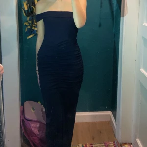 Klänning - Säljer denna fina klänning från PLT i storlek 6 (xs). Aldrig använd. Det är en one shoulder klänning med slits i marinblå, men man kan även ha den som en bandeau klänning. Köpt för ca 300kr.