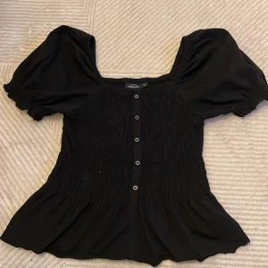 Blus - Svart blus med volang ned till. Strl xs 