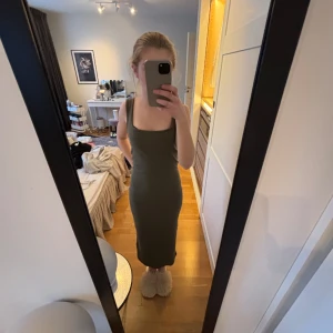 Militärgrön klänning - Säljer denna oanvända skit snygg lång klänning från lager 157 , köpte för 200kr men jag har aldrig använt den för att den är lite för stor i axlarna❤️