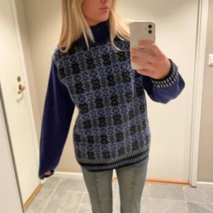 Stickad tröja  - Stickad tröja. Bak är den helt blå, inget mönster. Polokrage och väldigt varm. 