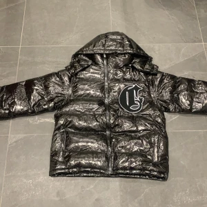 Svart glossy corvidae puffer - Riktigt fet corvidae puffer. Storleken M är lite stor storleken passar nog L.