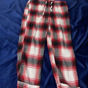 Randig mjukisbyxa röd - Randig mjukisbyxa röd. Står inte storleken men skulle nog säga M/L/XL. Passar till längden 1,65 cm ungefär. Fickor vid sidorna. Knappar som design. Vit snöre 