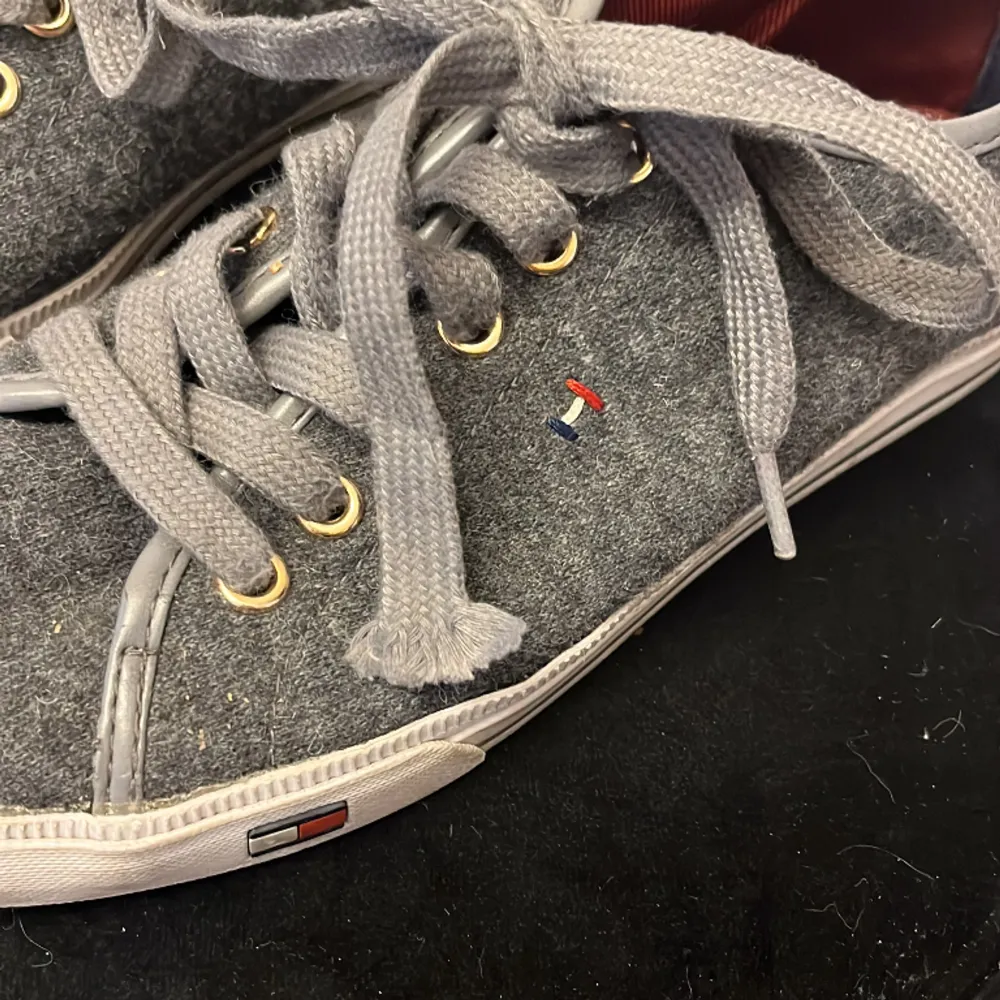 Sååå snygga låga skor från Tommy Hilfiger i perfekt grå färg. Ena skosnöret har tappat sin plastgrej längst fram (se bild 3), annars i gott skick! Skosnöret går enkelt att byta ut om man vill.. Skor.