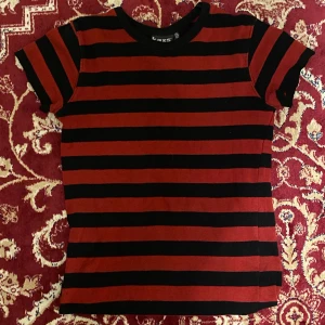 Randig t-shirt - Tight röd-och svartrandig t-shirt köpt second hand! Från början var det en långärmad tröja men jag har klippt av ärmarna💥