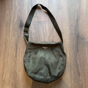 Prada Messenger Bag - Prada Messenger bag i bra skick, 2 små fläckar fram o bak. Nypris 8500 mitt pris 2500 sek. Bara att höra av sig vid frågor eller funderingar, över 60 refs finns! :)