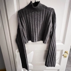 Stickad tröja, croppad  - En grå stickad tröja från NA-KD x widya soraya. Tröjan är i stl M och tyvärr aldirg använd. 