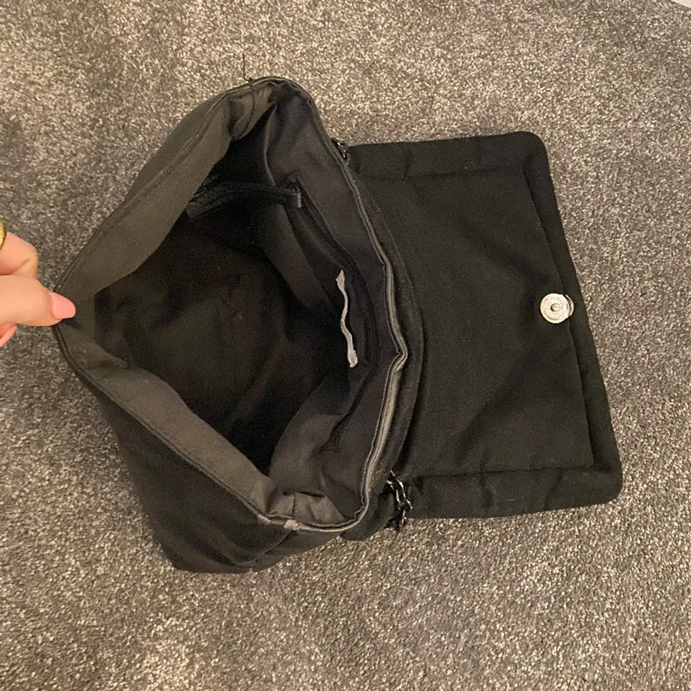 Perfekt svart handväska från HM med en kedja som axelband. Bandet är justerbart så man kan antigen ha väskan som på bilden på axeln eller som crossbody bag! Den är något sliten men ändå bra skick!. Väskor.