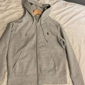 En grå Ralph lauren zip hoodie i storlek S men passar även M. Fick den i julklapp men den var lite för liten för mig. Den är använd ett fåtal gånger och är fortfarande i väldigt bra skick.