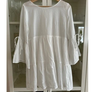 Vit sommarklänning  - Jättefin vit sommar klänning med knytning vid ärmarna. Från Gina Tricot i storlek S. 