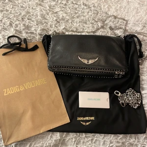 Zadig & Voltaire väska - Säljer min svarta Zadig & Voltaire väska. Det följer med två kedjor, men även bagen för att visa att den är äkta. Den är väl använd men inga skador. Dm för fler bilder på den🩷 