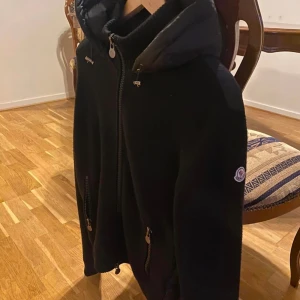Mocler cardigan - Säljer en cardigan i strlk M finns en liten skada som jag ringat in i bilden inget man tänker på . Givetvis äkta kan lösa fler bilder också