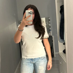 Vit zara top - Säljer denna superfina vita t-shirten med detaljer på armarna från zara. Den är helt oanvänd och har som man ser prislappen kvar, pris kan diskuteras 💕skulle säga att den absolut passar någon med S