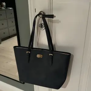 En marinblå hand väska från Michael kors som är super fin och i bra skick, skriv för funderingar🩷