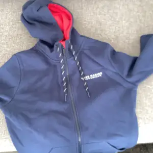 Här är en zip-hoodie jätte fin mörkblå pris på den är 450 säljer den för 300 använd Max 1 gång ålder på den är 12-13-14.
