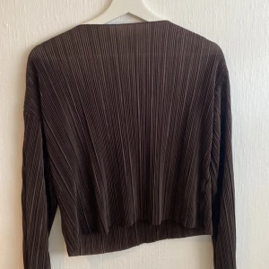 Blus - Mörkbrun blus från Monki med utsvängda ärmar