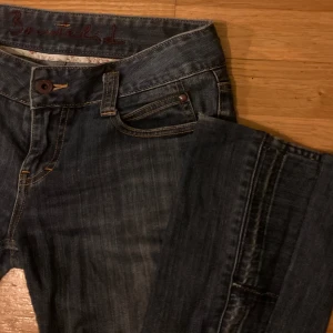 Utsvändga jeans - 85 cm i midjan och 93cm i längden, bra skicka, de har sött blommigt tyg på insidan av fickorna, och cola detaljer vid utsvängningen