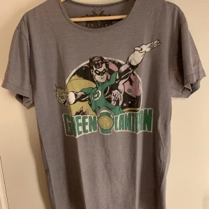 Green Lantern T-shirt - Green Lantern T-shirt i storlek M-L=63cm lång, 50cm bred. Mät gärna en t-shirt och se om den passar, eller skriv hur lång du är så kan jag säga om den passar eller ej.