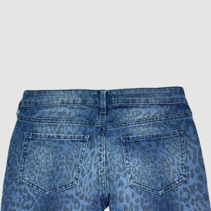 Lågmidjade Leopardjeans - Mer info och möjlighet att köpa plagget finns på vår hemsida 😊 MODELL: Lågmidjade. FÄRG: Blå. STORLEK: 34 enligt lapp.  MIDJA RAKT ÖVER: 35,5 cm. MIDJEHÖJD: 18 cm.