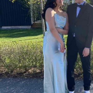 Blå satinklänning  - Säljer klänningen jag hade på balen i 9an, 2021! Använd 1 gång så inga defekter, köpt för 1100 kr och den finns ej kvar hos Nelly längre 