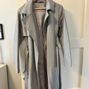 Skinnkappa - Grå lång skinnkappa med skärp. Aldrig använd. 