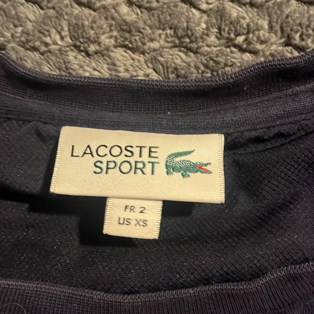 Mörkblå Lacoste tröja. säljs för att den har blivit för lite. Skriv för minsta intresse!. Tröjor & Koftor.