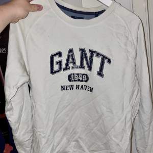 Vit Gant sweatshirt i storlek 176. Trycket var inte slitet frön början utan har slitits i tvätten. 