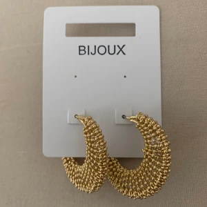 Guldfynd smycken - Helt nya och oanvända örhängen och armband från Guldfynd.   1. Örhängen Miriam: Guldfärgade creoler med kulor. 60kr (originalpris 79.50kr) 2. Armband Lilly: Guldfärgat armband med band av löv och vita kristaller. 40kr (originalpris 69.50) 