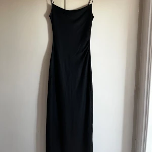 Svart långklänning  - Svart långklänning, något skimmrig