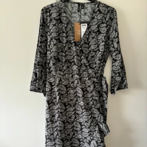 Omlottklänning paisley-mönster - Vero Moda storlek L. Ny och oanvänd klänning med lapparna kvar. Paisley-mönster i svart/vitt.