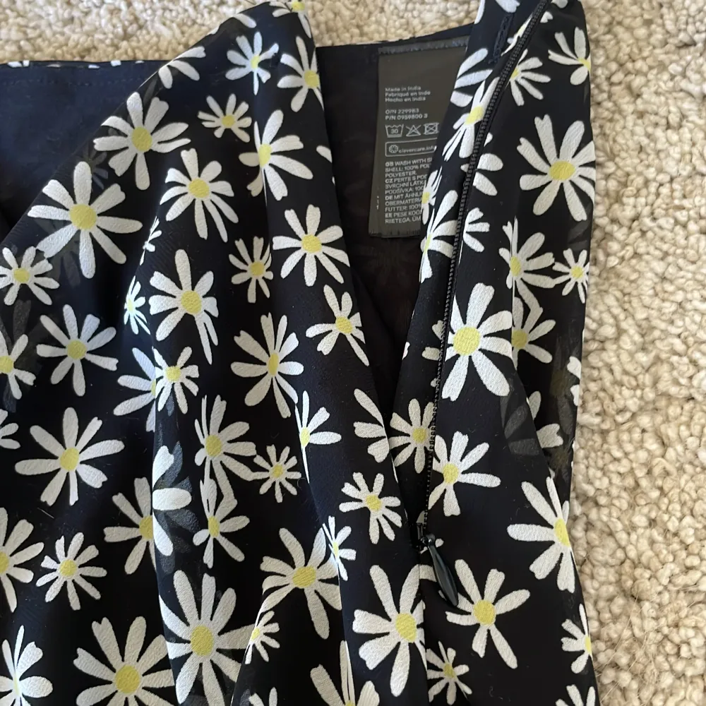 Säljer denna svarta kjolen med vita blommor på, är inte stretch bar och har en dragkedja på sidan! Knappt använd! Kontakta vid intresse💗. Kjolar.