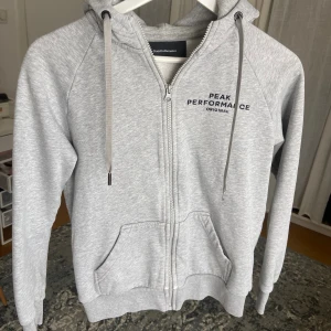 Zip hoodie - Ziphoodie från Peak Performance. Defekt på andra bilden, ena snöret saknar ”knopp”.