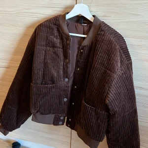 Fin oanvänd ’collegejacka’ - Collegejacka modell från HM. Aldrig använd, storlek m men är mer som en S/lös passform. Fin chokladbrun färg i fint material. Passar vår/höst/sommar. 