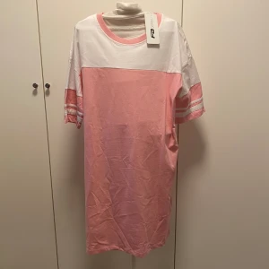 Klänning  - Rosa och vit klänning aldrig använd med lapp kvar