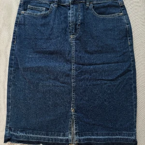 Jeanskjol  - Knälång jeanskjol. Storlek 38. 