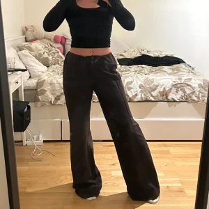 Mörkbruna kostymbyxor  - Mörkbruna kostymbyxor, köpta secondhand och står inget märke eller strl. Har sytt in resår i midjan så just nu strl S, sprättar man upp resåren är de L!