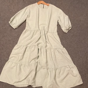 Grön klänning  - Använd en gång. Storlek 140/9-10 år. Ganska bred i midjan så om man är lite smalare så rekommenderar hag att man använder ett skärp. 