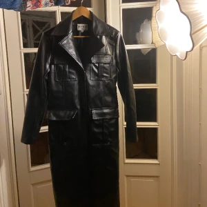 Lång skinnkappa  - Här är en lång skinnkappa i svart färg som aldrig är använd. Den är i storlek s och har snygga spetsiga axlar❤️