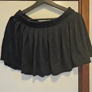 Beskrivning: Kort svart rynkad kjol Märke: Divided Storlek: Står 34, men skulle säga small Skick: Bra skick Material: 65% polyester, 35% viskos   Nakenkatt finns i hemmet