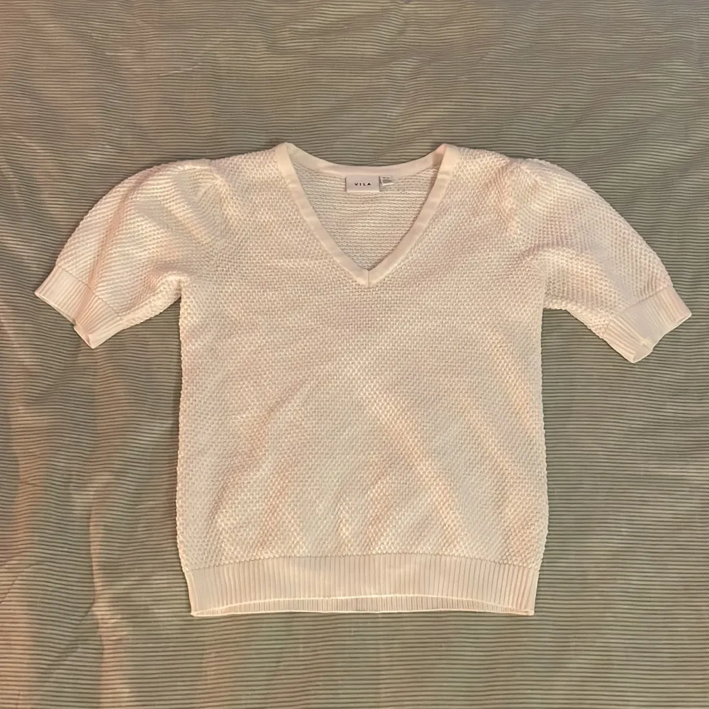 Vit stickad TShirt. Använd fåtal gånger. Inga defekter förekommer. Storlek XS. Köpare står för frakt.. Neuletakit & Villapaidat.