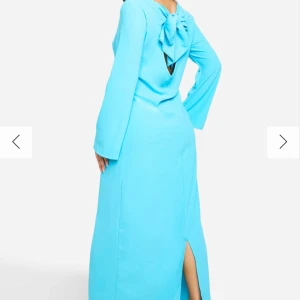 Jättefin blå klänning - Jättefin ljusblå långklänning med knytning i ryggen. Aldrig använd helt ny fortfarande i förpackning