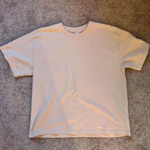 Beige t-shirt - Beige t-shirt i tjockare material vilket gör den lite finare! Använd ett fåtal gånger så den är i väldigt bra skick.  Måtten är från hals till nedersta kanten 52cm, 52cm bred och från ärm till ärm 73cm. 