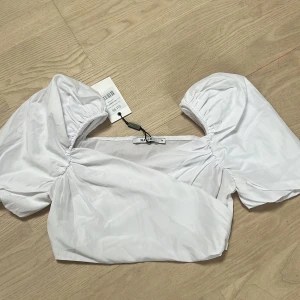 Vit blus - Omlott, croppad. Aldrig använt, har dock fått sminkfläckar (se bilder) när jag provat, går kanske att få bort i tvätten! Därav billigt pris :)