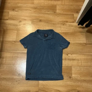 Robbie Moor frotté pike  - Säljer denna blåa Robbie Moor pike, väldigt fint skick, storlek M, frotté material, kan mötas upp. 